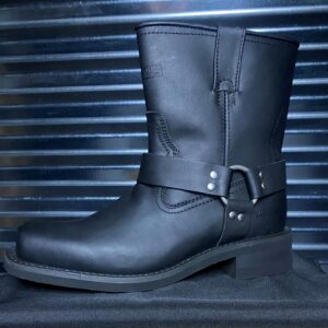 A black leather boot sitting on top of a metal surface.