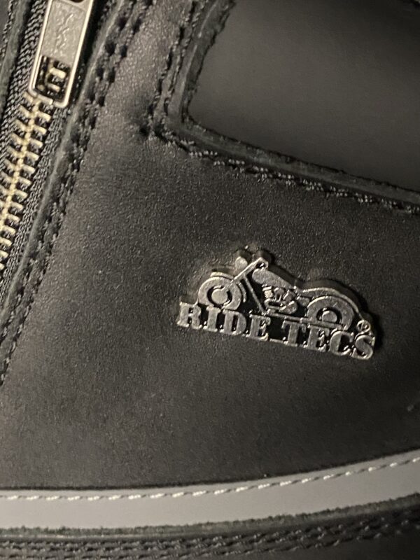 A close up of the ridding shoe logo