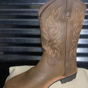 A brown cowboy boot sitting on top of a box.