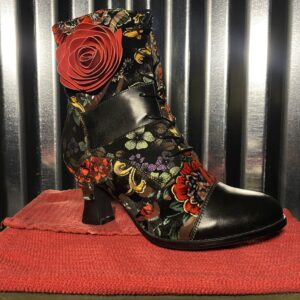 A black and red floral print boot sitting on top of a table.