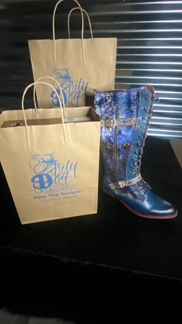 A pair of boots sitting next to a bag.