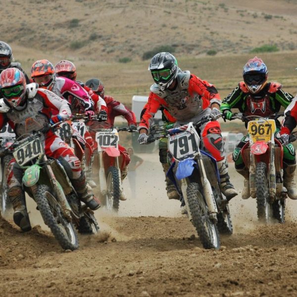 A group of people riding motorcycles on top of dirt.